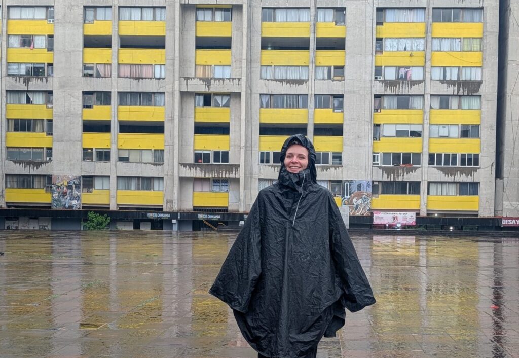 Voyageuse en poncho de pluie sur la Plaza de las Tres Culturas à Tlatelolco, Mexico, un jour d'averse en juillet